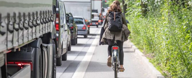 Riding Bicycle on city street with cars & trucks