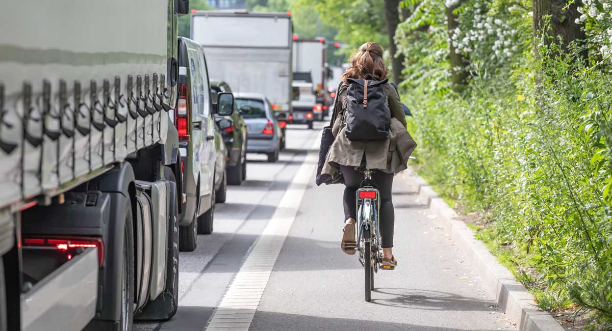 Riding Bicycle on city street with cars & trucks